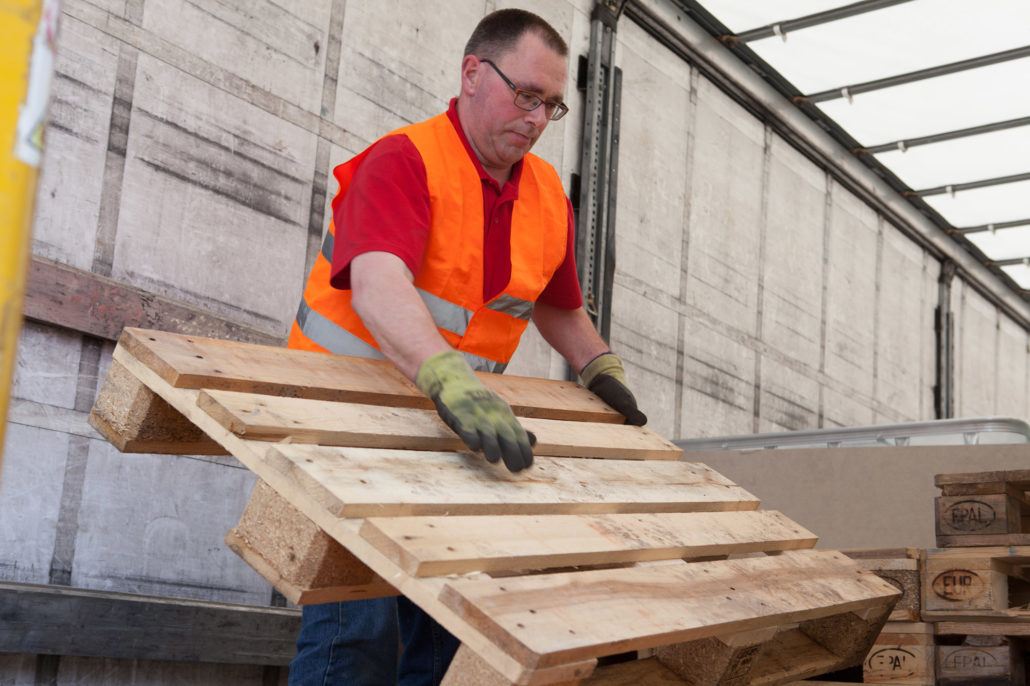 Willy Willemsen stapelt retour-pallets.